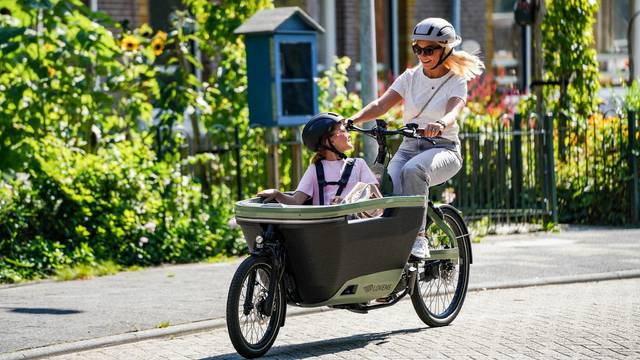 Mutter mit Kind auf Lastenfahrrad unterwegs