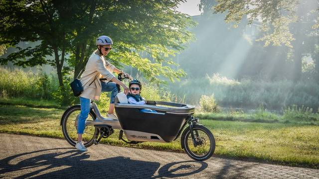 Mutter mit Kind auf Lastenfahrrad unterwegs